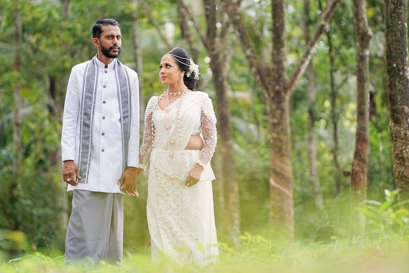 Sri Lankan couple in traditional wedding attire in serene forest